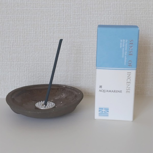 陶器の香皿に立てたお香と「澪 AQUAMARINE」のパッケージ